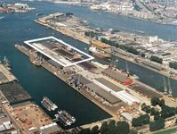 The photo is taken from above. There are four land parts with buildings and cars on them. The parts are seperated by water.