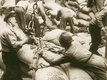 An old sepia photo of port workers with coffee bags, probably on a ship. It is unclear if they are loading or unloading the bags.