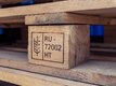 Close-up of a wooden pallet. One piece is engraved with the code RU-72002.