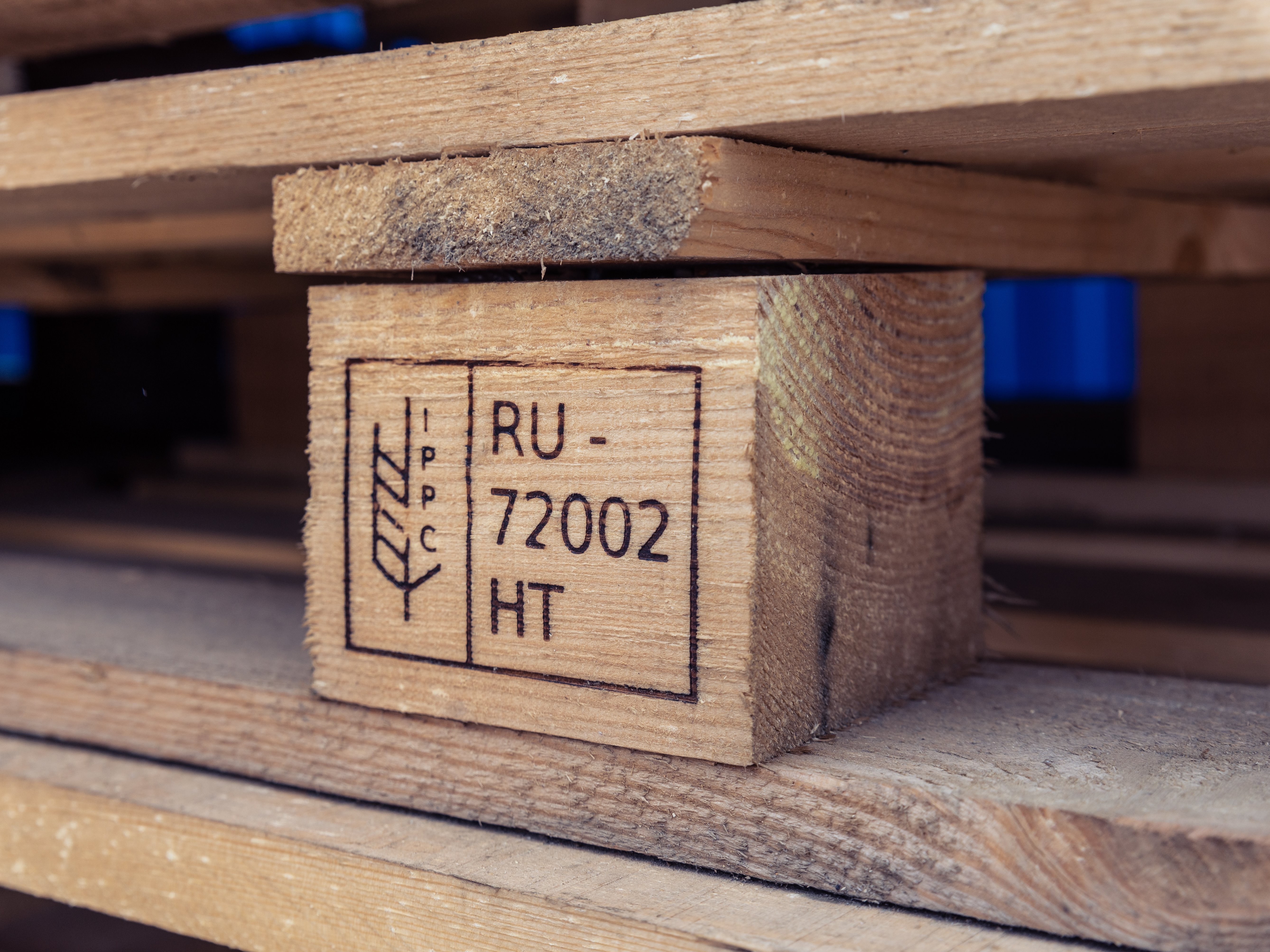 Close-up of a wooden pallet. One piece is engraved with the code RU-72002.