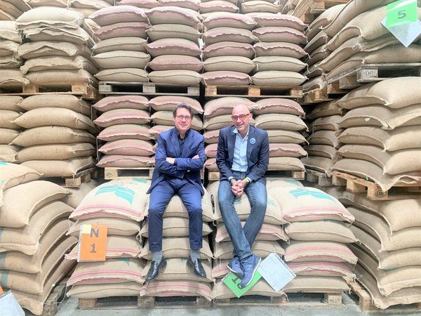 General Managers Rosario Carafa and Maurizio Zugna sitting on coffee bags in the warehouse in Naples