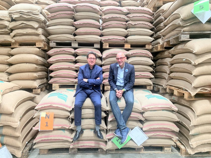 General Managers Rosario Carafa and Maurizio Zugna sitting on coffee bags in the warehouse in Naples