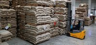 Coffee bags on pallets are stacked by an employee with a forklift in the Naples warehouse