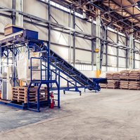 A team of four people standing in front of coffee bags on pallets inside the warehouse of Trieste